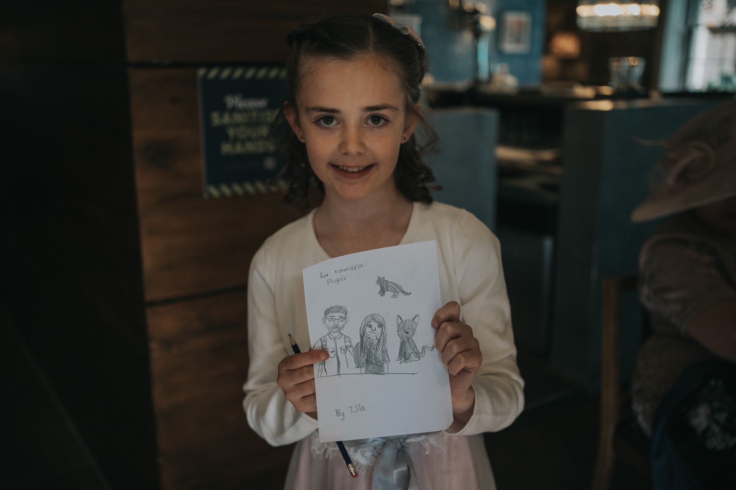 Young girl holds a drawing of two wedding photographers at the Bothy Glasgow