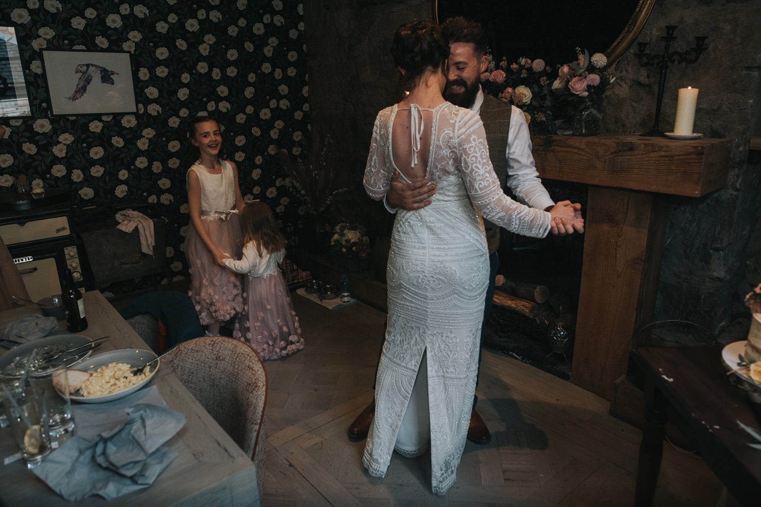 The newly weds dance whilst their small daughters dance in the background 
