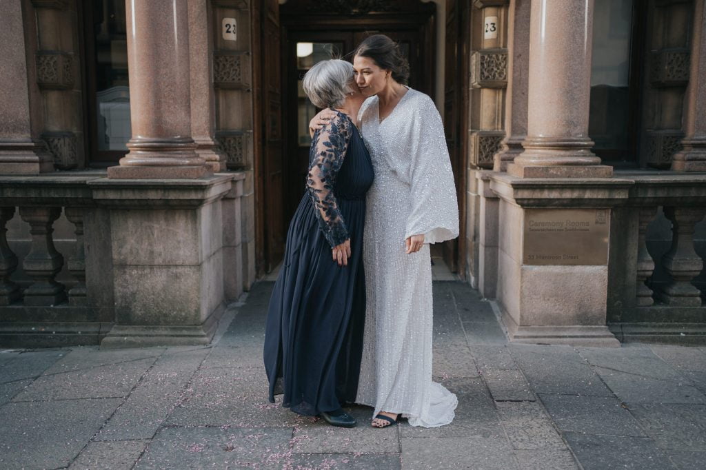The bride kisses her mum outside the doorway of 23 Montrose Street