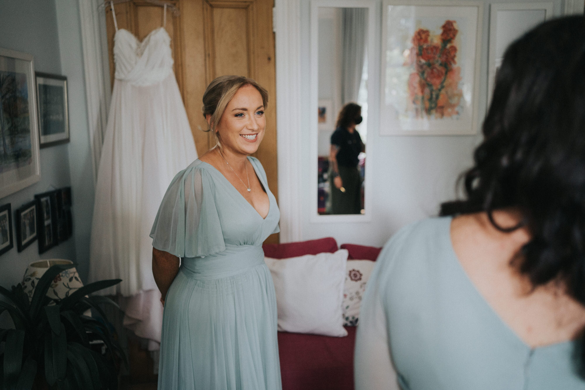 A bridesmaid smiles as she chats to another bridesmaid