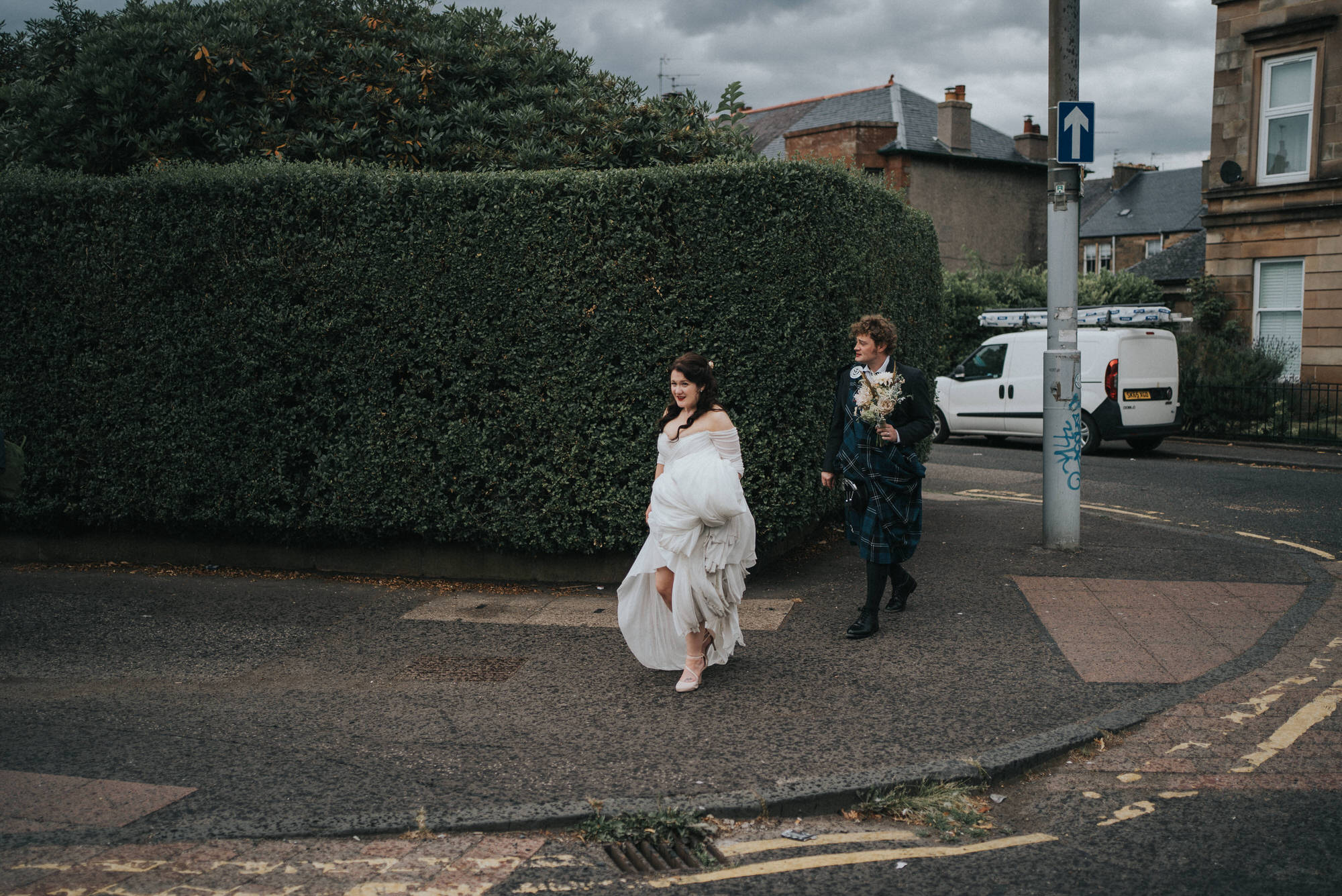 A bride and groom walk through the streets of Glasgow
