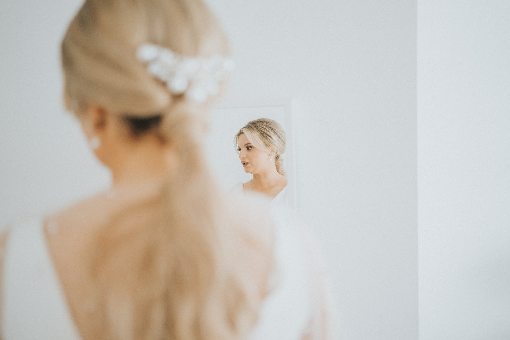 The bride is looking at herself in the mirror