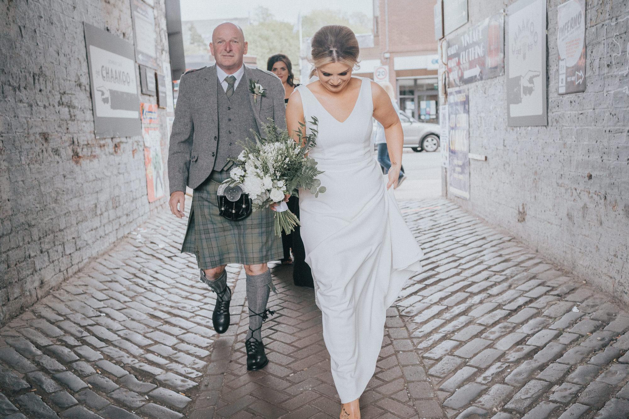 The bride and her dad walk down a cobbled street to The Bothy, Glasgow