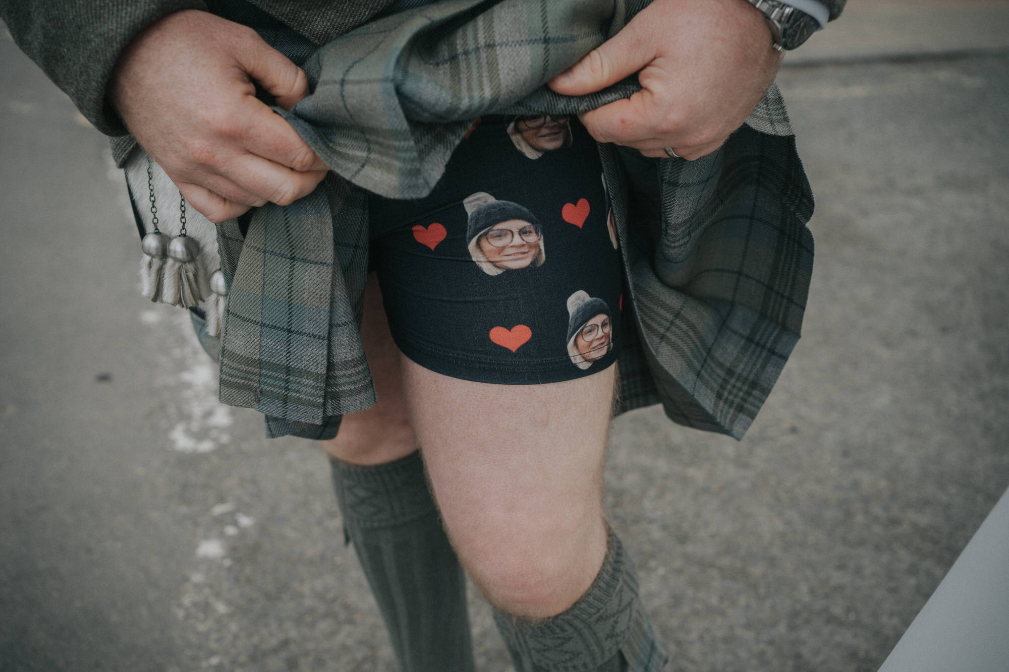A groom shows off his boxer shorts - they have hearts and pictures of his new wife's face on them