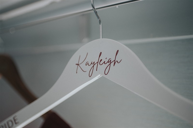 The Brides name "Kayleigh" is etched onto her the coat hanger that holds her dress.