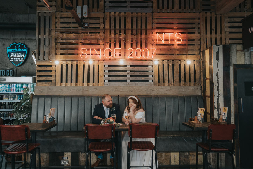 A bride and groom sit enjoying some drinks in Brewdog in Glasgow