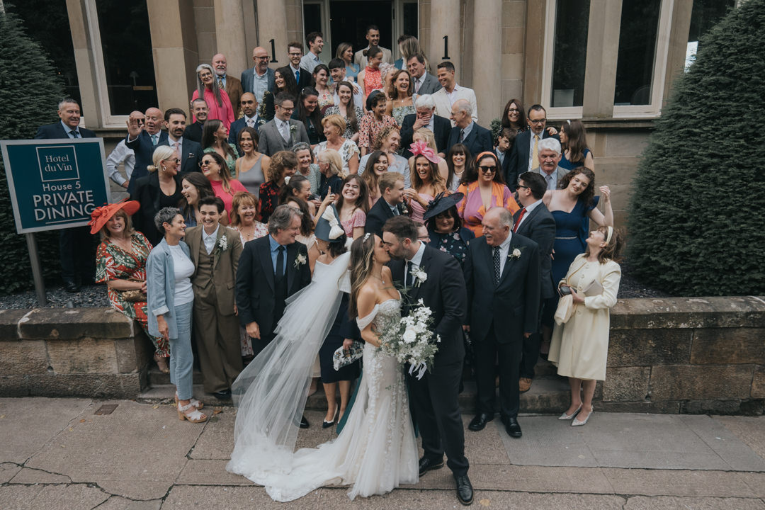 its a large group shot on the stairs of Hotel Du Vin in Glasgow. 
The bride and groom kiss at the front 