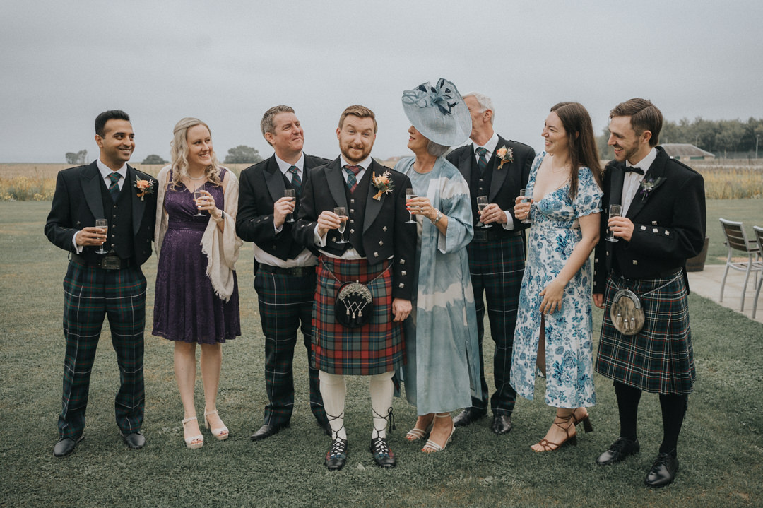 A groom and his bridal party share a drink and a laugh before making thier way to Kinkell Byre in St Andrews