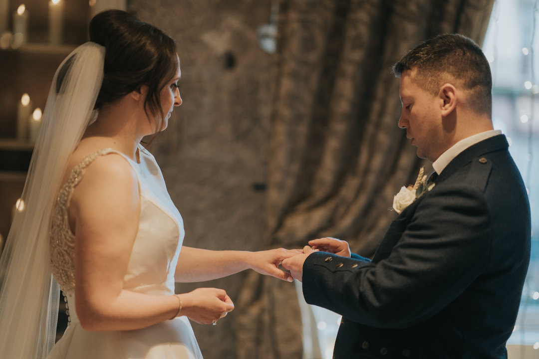 The groom places the ring on his brides finger at Citation Weddings & Events in Glasgow