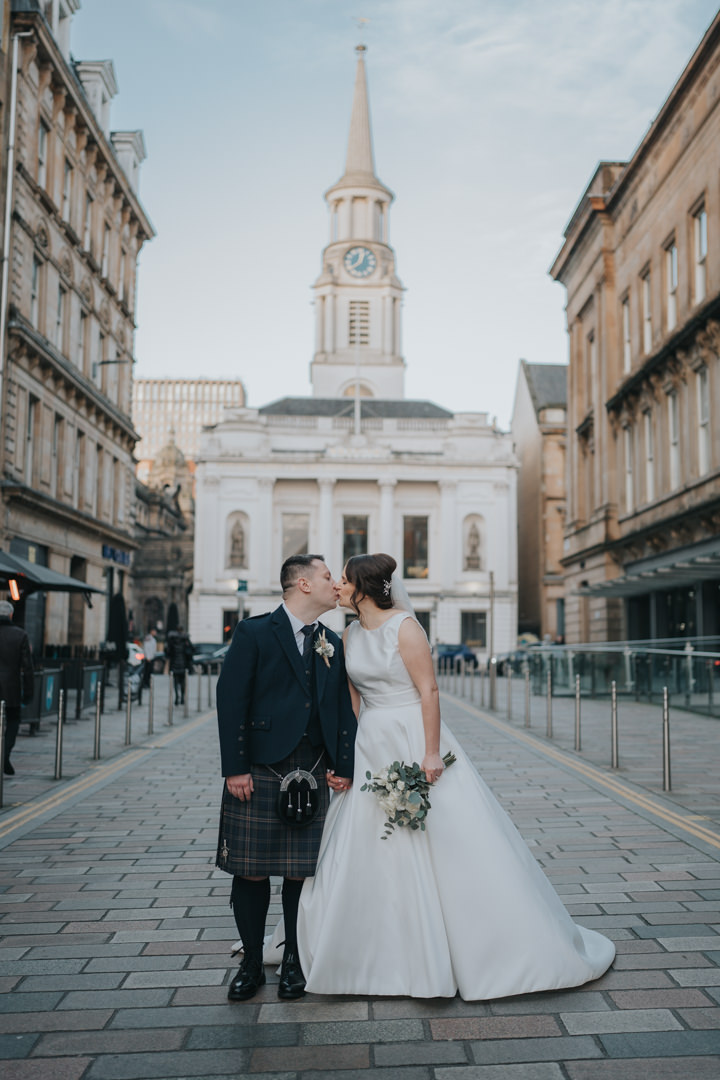 A bride and groom share a kiss just outside of Brewdog in Merchant City